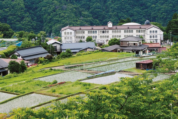 青根の南側にある浄水場付近からの眺望。大きな建物は青根の小・中学校。2020年に閉校した。