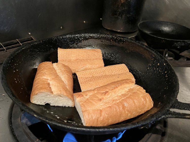 フライパンにたっぷりバターを入れバゲットをこんがり焼く。