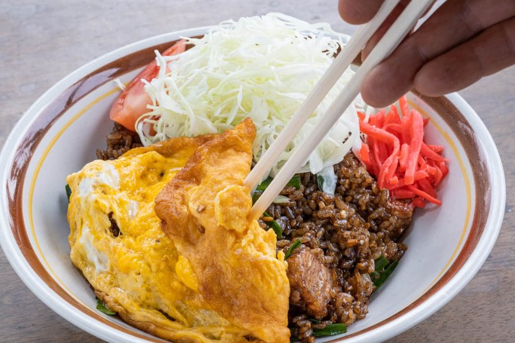 卵焼きの下に隠れている鶏の唐揚げも人気の黒チャーハン。