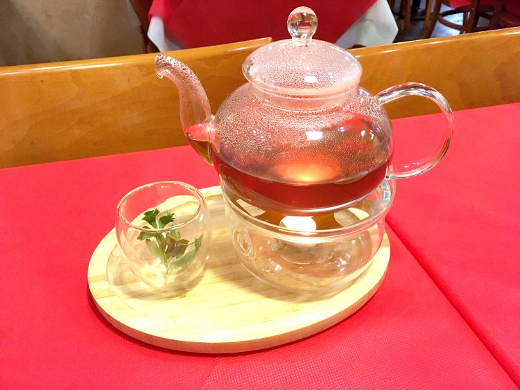 自家引きコンソメスープ990円。グラスのイタリアンパセリの風味が味を引き立てる。