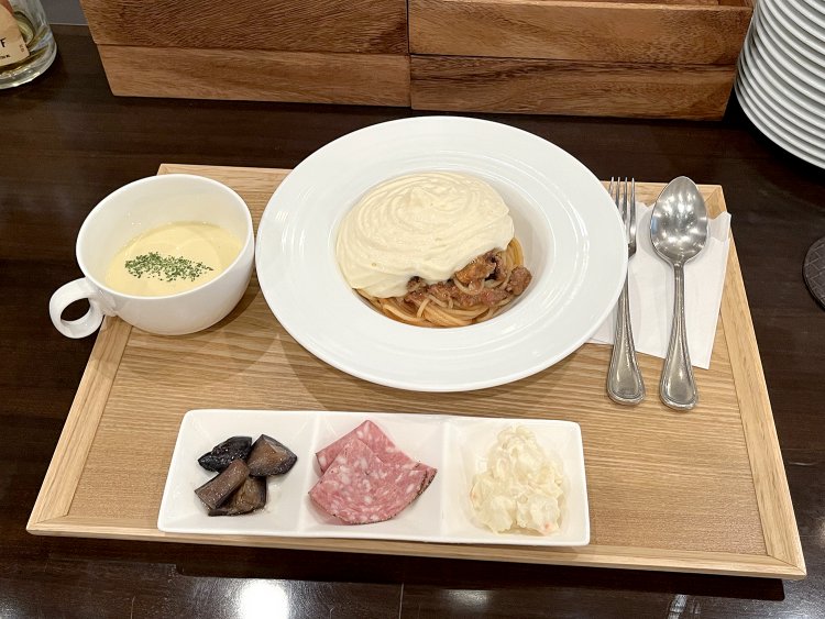 ホワイトミートソース1580円。前菜が3種付く。この日は左からナスのバルサミコ、ハム、ポテサラ。そして冷製のコーンスープ。これらは季節により変わる。