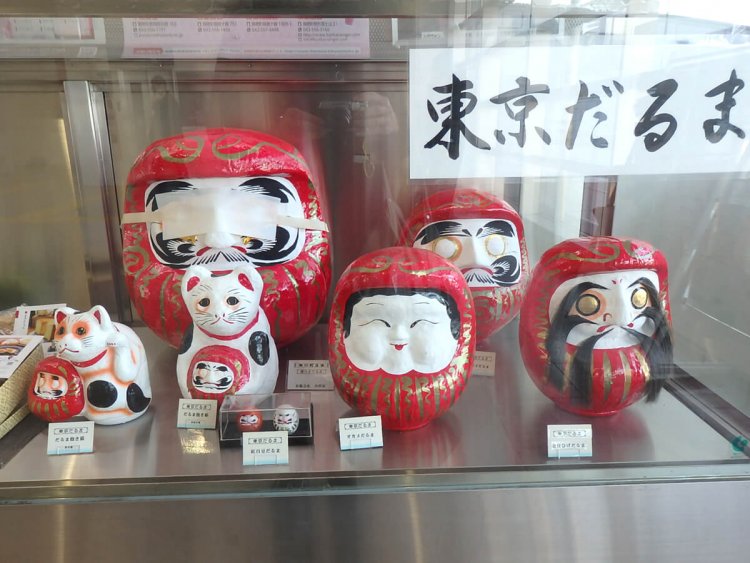 箱根ヶ崎駅の物産ケース。ひげだるまがちょっと怖い。