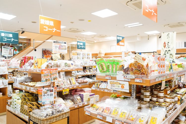 店内には所狭しと名産品が並び、愛媛県はオレンジ、香川県は緑と、看板や値札の色で商品の産地が見分けられるようになっている。