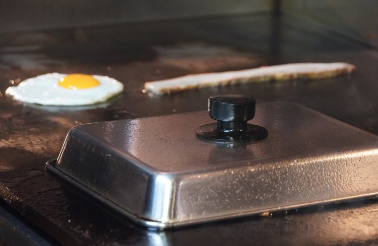 蓋をして蒸し焼き。奥では同じ焼麺にのせる目玉焼きとチャーシューを焼く。