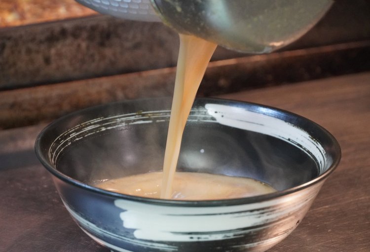 ネギ油を入れた丼に、乳白色でとろ〜りとしたスープをたっぷり入れる。