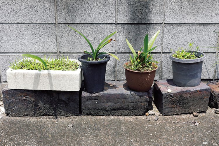 写真の黒い石が銅の精錬過程の廃棄物で造られた鍰（からみ）煉瓦。日露戦争下にここ豊島で造られた記録が残る。