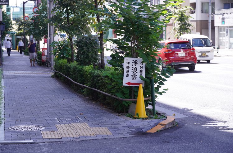 池袋駅から店へ向かう明治通り沿いの小さな看板。