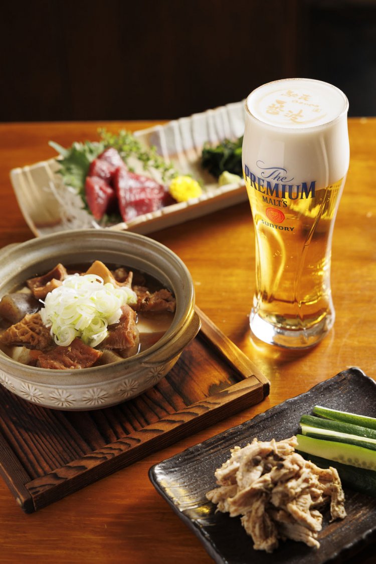 左の牛もつ煮込み540円（季節限定）、くじら赤身刺650円、神泡アートが美しいザ・プレミアム・モルツ中550円。
