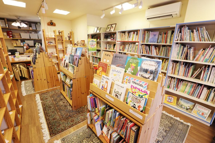 中央の3つの島は新刊コーナー。壁沿いの棚には、チェコなど東欧の絵本が並ぶ。