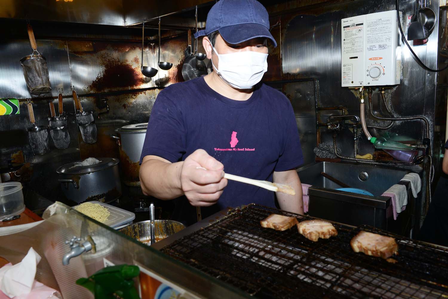 提供前に炙るちゃーしゅー。「皮付きの豚肉は奄美地方から取り寄せています」と松田さん。