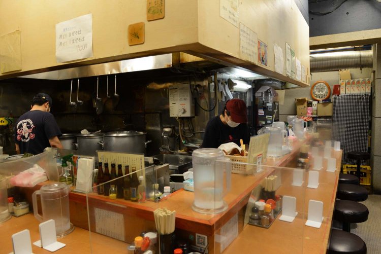 店内の壁には地元の徳之島のポスターや黒糖焼酎がある。