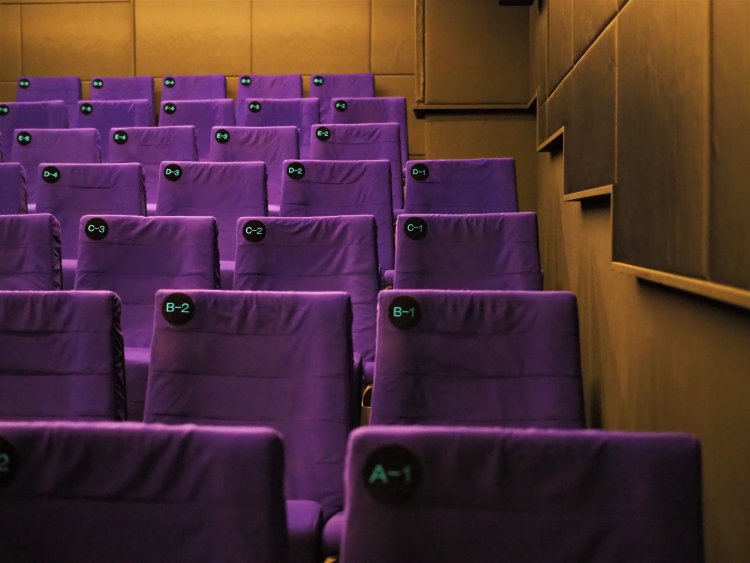 入り口にはブルーが目を引く劇場ロゴが。ガラス張りでオープンな雰囲気はまるでカフェのようだ。劇場内は49席の小さな空間とあなどるなかれ。こだわりの座席と音響設備は体験必至！