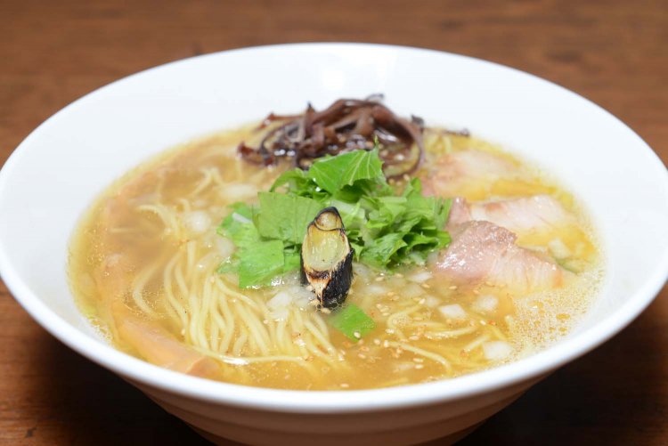 水菜の彩りや焼きネギのほのかな香ばしさが感じられる塩そば。鶏のコラーゲンもたっぷり。