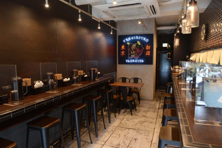 テーブル席のほかは、カウンター席。中央で光るネオンサインが印象的。