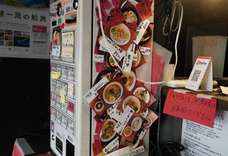 これまでの限定メニューが券売機を飾る。食材も味付けも実にさまざま。