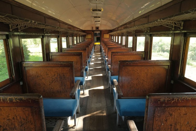 オハフ61形の車内。背もたれは木の板であった。シートは張りがあって座るとズシンとくる。面白いのはデッキにあるスイッチを押すと走行音がスピーカーから流れ、あたかも乗車している気分にさせてくれる。