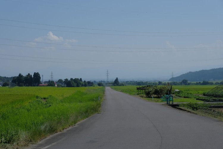 生活道路となった廃線跡。やがて立派な県道へと吸い込まれていく。日中線の廃止後は、線路が道路へと転用されていった典型的なパターンである。