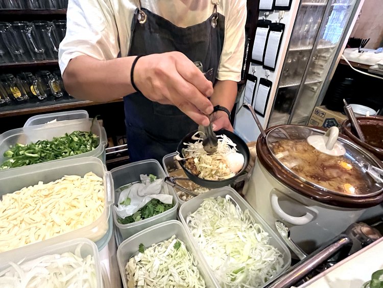 マリネしたキャベツや高菜、紅生姜やシャキシャキのネギを乗せる。