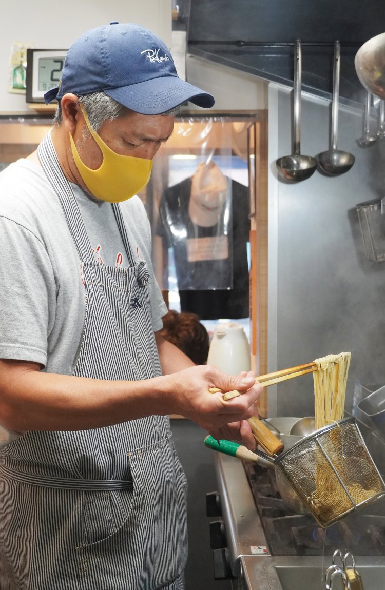 ガタイのいい渡邊さん。湯切りをしながら丁寧に麺を揃える。