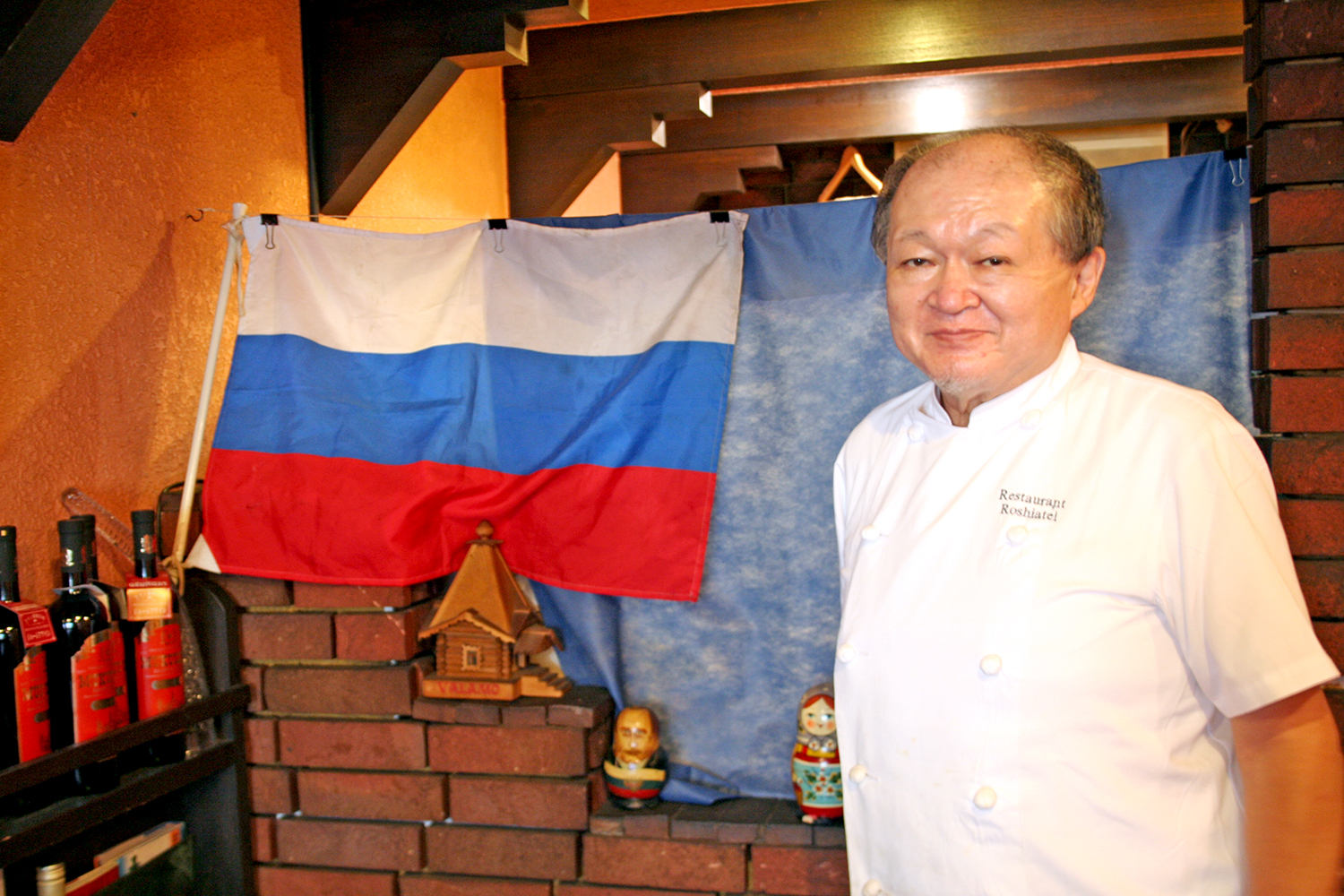 白・青・赤の“スラブ三原色”と呼ばれるロシアの国旗と、オーナーの北市泰生さん。