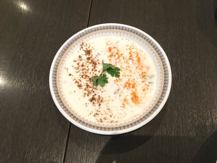 ライタ（ヨーグルトのサラダ）。刻んだ野菜と香辛料が入っている。酸味は控えめだ。