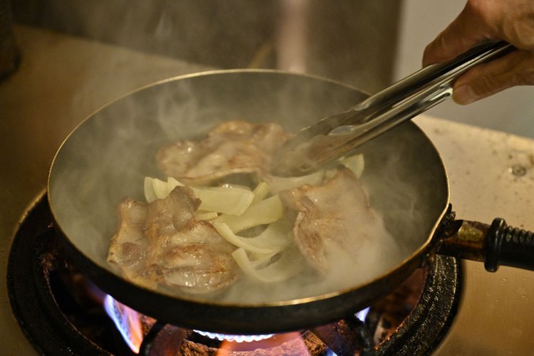 豚の肩ロースをあぶり、先に火入れしたタマネギをサッと合わせる。