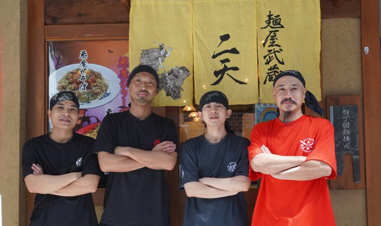 おなじみのラーメン店ポーズのスタッフ。赤いTシャツが店長の大原さん。