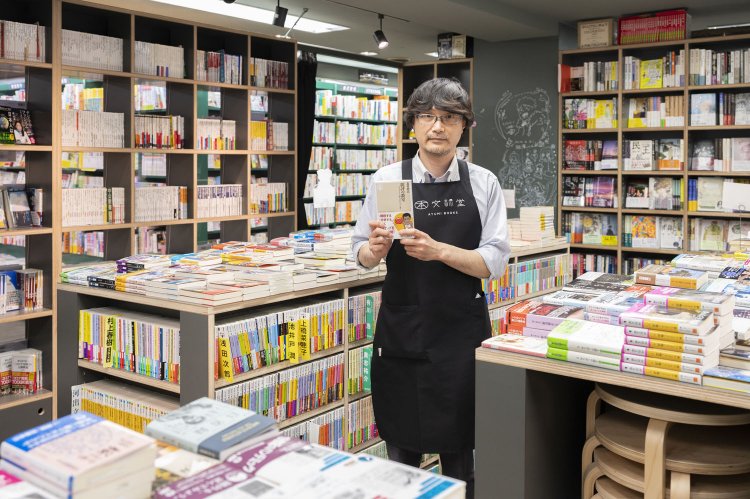 店長（取材時）の山田さん。文庫棚は可動式でイベント開催が可能。「『批評の教室』。北村紗衣先生の本は間違いありません」。