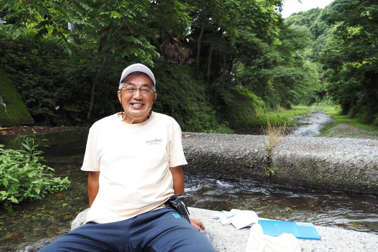 『鈴木商店』の“川守り”鈴木彰さん。毎朝、川を見守っている。家の前を流れる沢井川にて。
