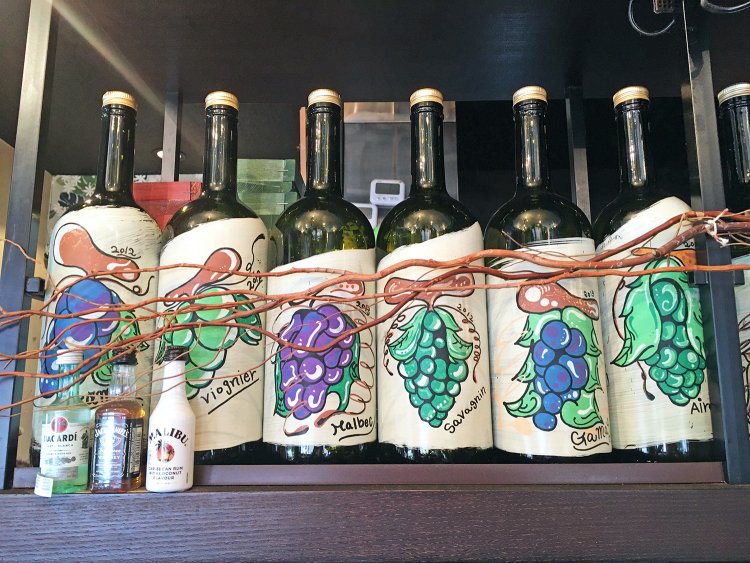 店内に飾られたワインボトル。ラベルは圭一郎さんの手描きだそう。