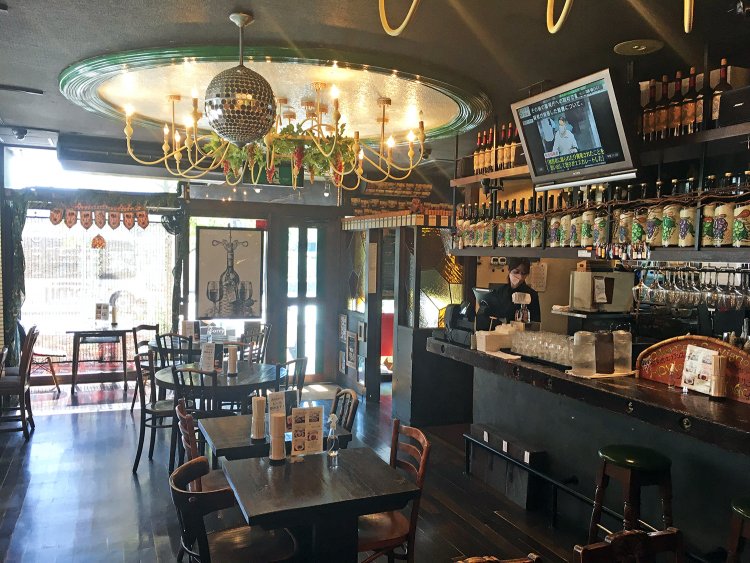 アンティーク調のテーブルと椅子が並ぶ店内。天井には大きなシャンデリア。