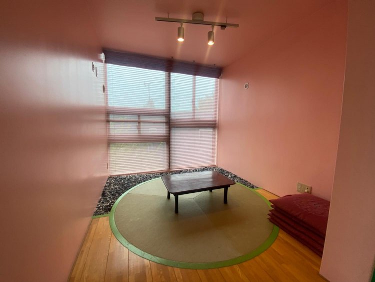 斬新なピンク色の和室。奥には石が敷き詰められ、庭のように楽しむこともできる。