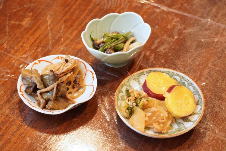 おばんざいは日によって異なるが、サツマイモと大根の煮物やナスとレンコンの炒め煮など野菜たっぷりの料理が並ぶ。