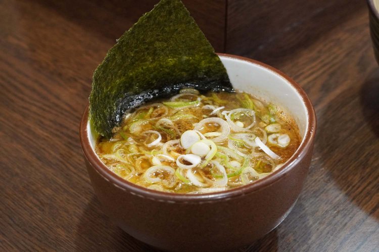 つけ汁の中にはたっぷりの刻みネギや海苔、メンマ、そして丼の底にはゴロッとチャーシューが沈んでいる。