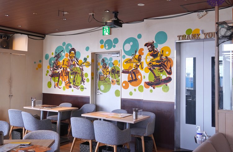 エレベーターの扉が開くとすぐ店内。壁にはポップなグラフィティアートが踊る。