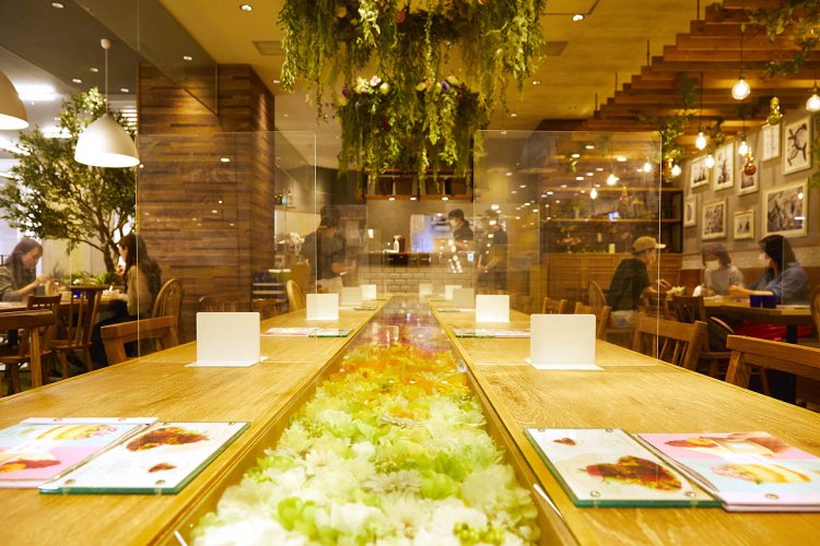 開放的な空間で立ち寄りやすい店内。テーブルには花がいっぱいある華やかな雰囲気。