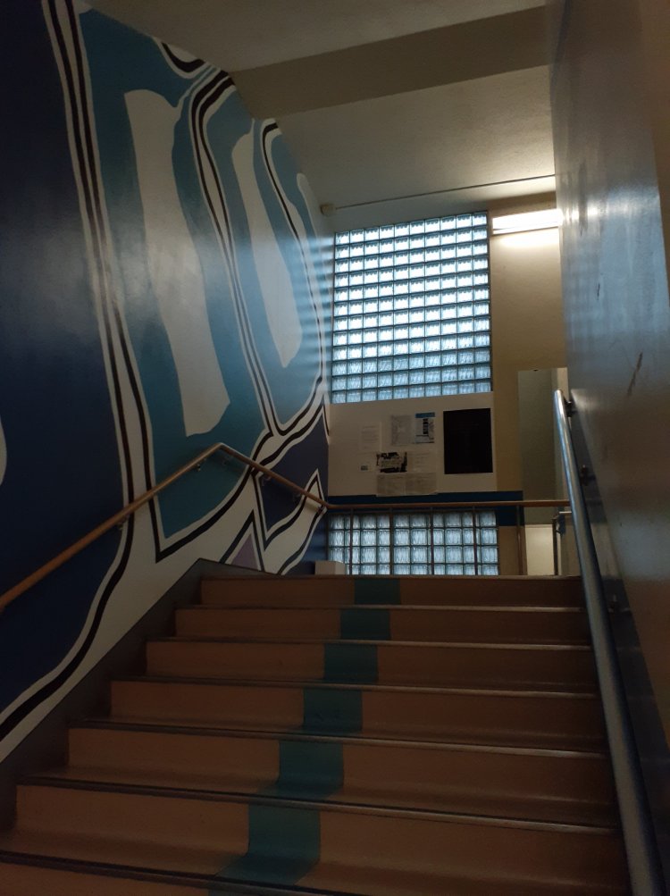 ガラスブロックを通して階段踊り場に外からの光が漏れ込む。