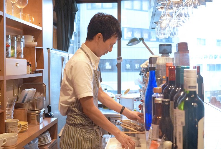 店長の岸山さん。右側が客席で、厨房の奥まで全部窓だ。