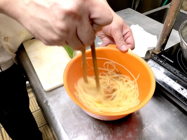 ミートソース、卵、チーズが入ったボウルに茹で上がりのパスタを投入。
