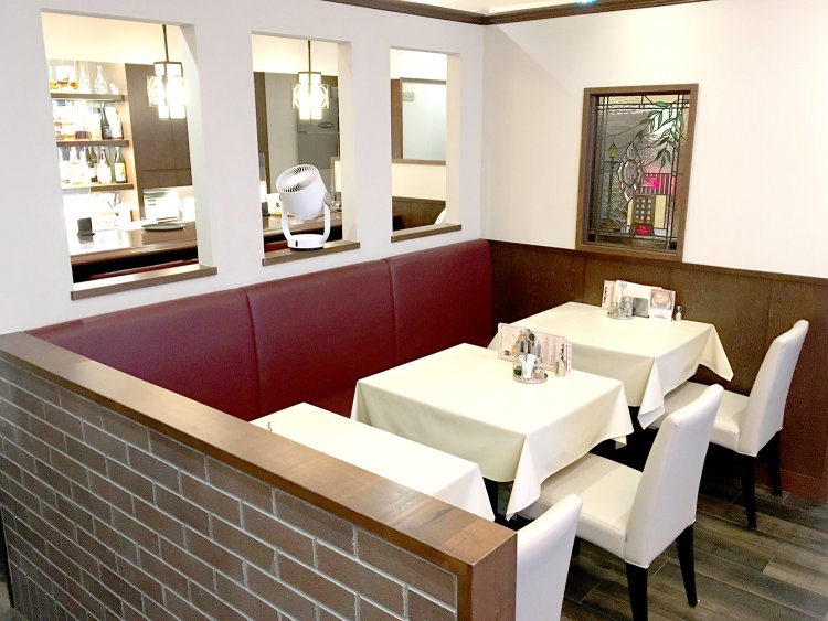 白いテーブルクロスとシックな装飾品。ステンドグラスにも注目したい。