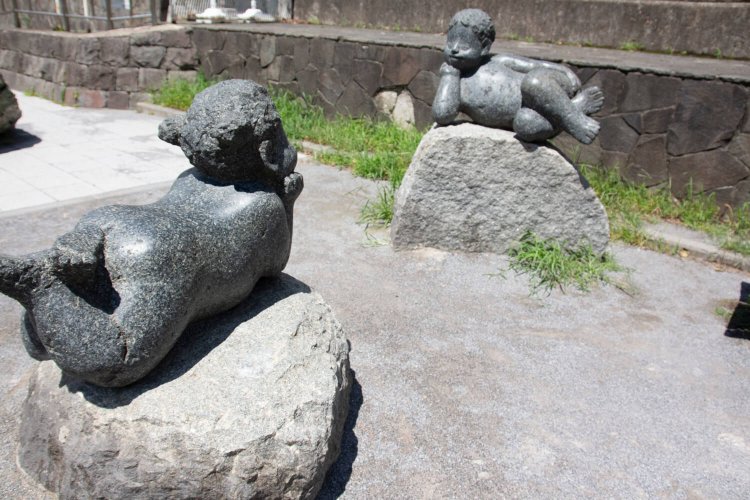古石場親水公園の石像。東西に伸びる水路沿いには、ボタンやバラなど季節の花が咲く。