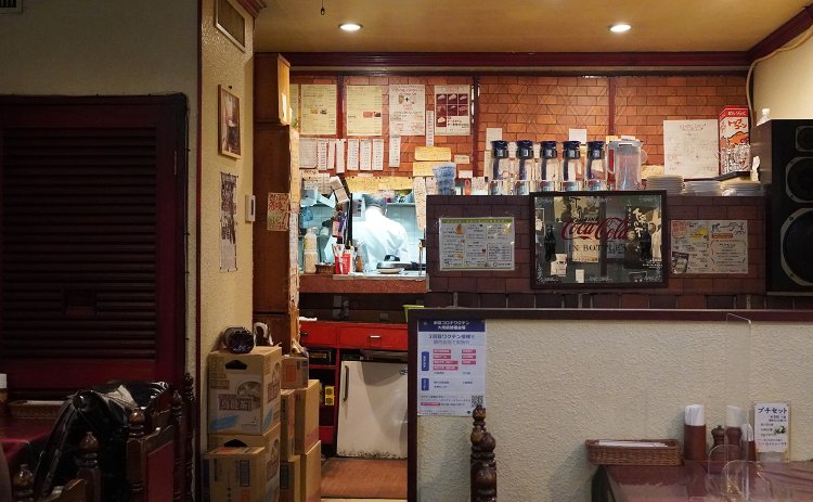 小窓の向こうに厨房に立つ榎本さんの後ろ姿。