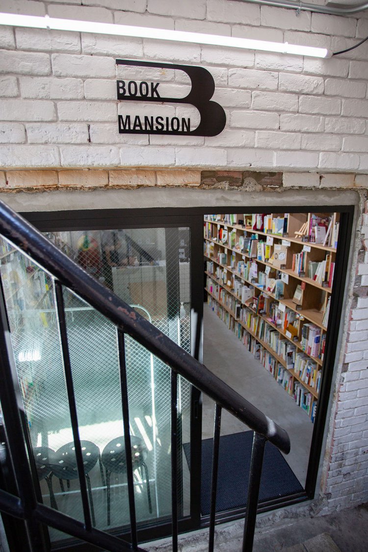 外階段から店内へ。棚の個性、手書きコメントに触れ、つい長居に。