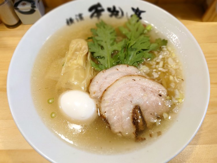 本丸塩らー麺900円。透き通ったスープに、具はチャーシュー、ワンタン、春菊、ネギ、追加の塩煮たまご。