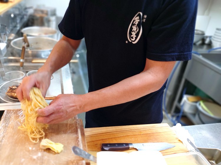 国産小麦100％と素材にもこだわった自家製平打ち麺。茹でる直前に手揉みして、ほどよい縮れをつける。
