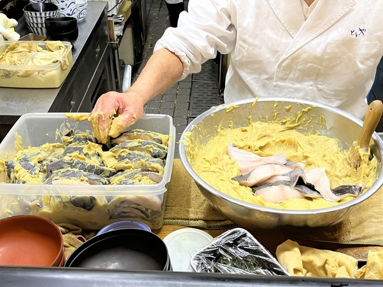 仕込み中に拝見した西京味噌に漬けられる銀だら。「このタッパーにだいたい60切れくらい入るかな。でも、食べられるのは2日後だよ」と笑う宮崎さんだ。