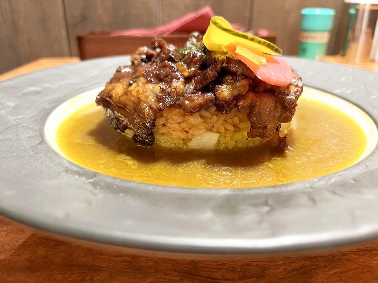 カレーの海に浮かぶ3つの地層、もとい馳走か。鈴かぼちゃと紫大根のピクルスが、南国の花のように鮮やかだ。