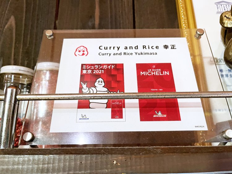 スパイス棚の横に飾られている栄光のミシュラン・ビブグルマンの盾。