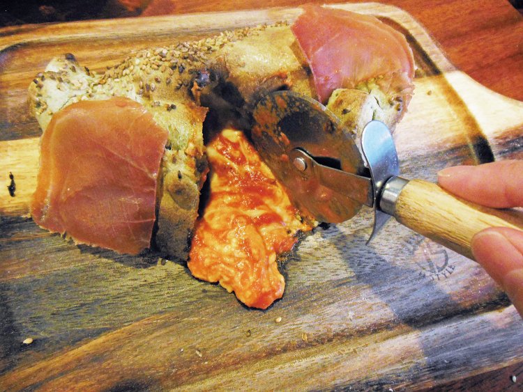 ピザカッターでザクッと切り込みを入れると、中からチーズとトマトソースがとろ～り。