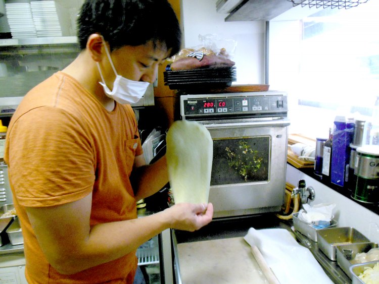 イタリア料理人として20年の職人歴をもつ髙宮さん。注文を受けるごとに生地をのばしてピッツァを焼き上げる。